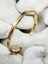 Solid gold bangle on stone background