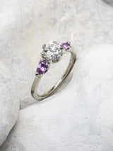 Handmade trilogy engagement ring with amethyst shoulders