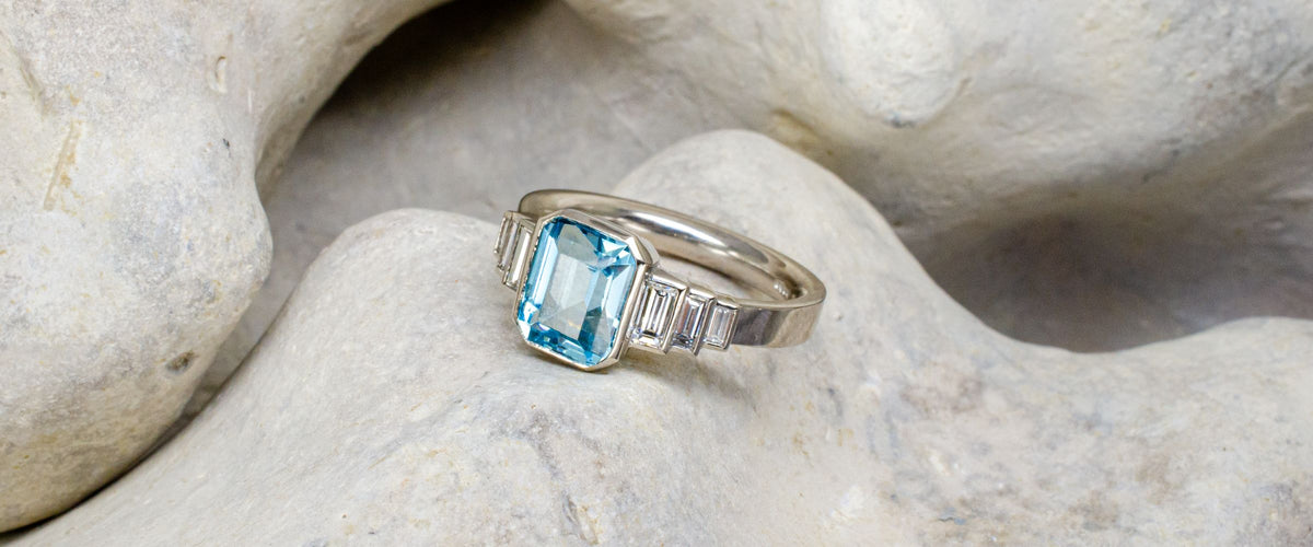 emerald cut aquamarine and diamonds on rocky background