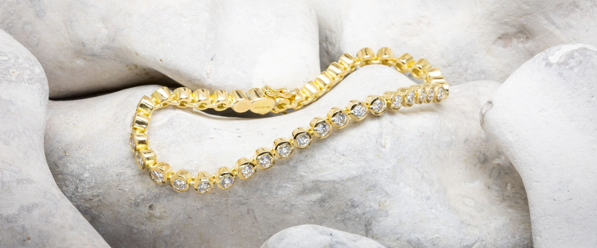 silver and gold nugget bracelet on rock background