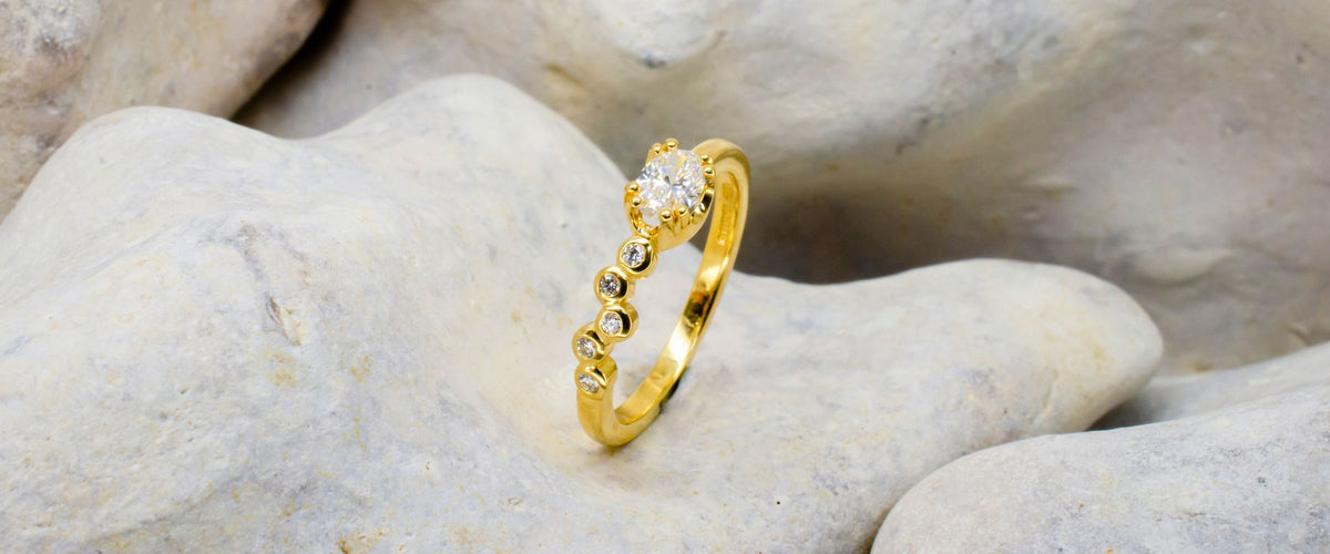 Gold and diamond roman inspired ring on rock background