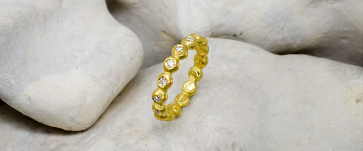 Gold nugget ring on rock background