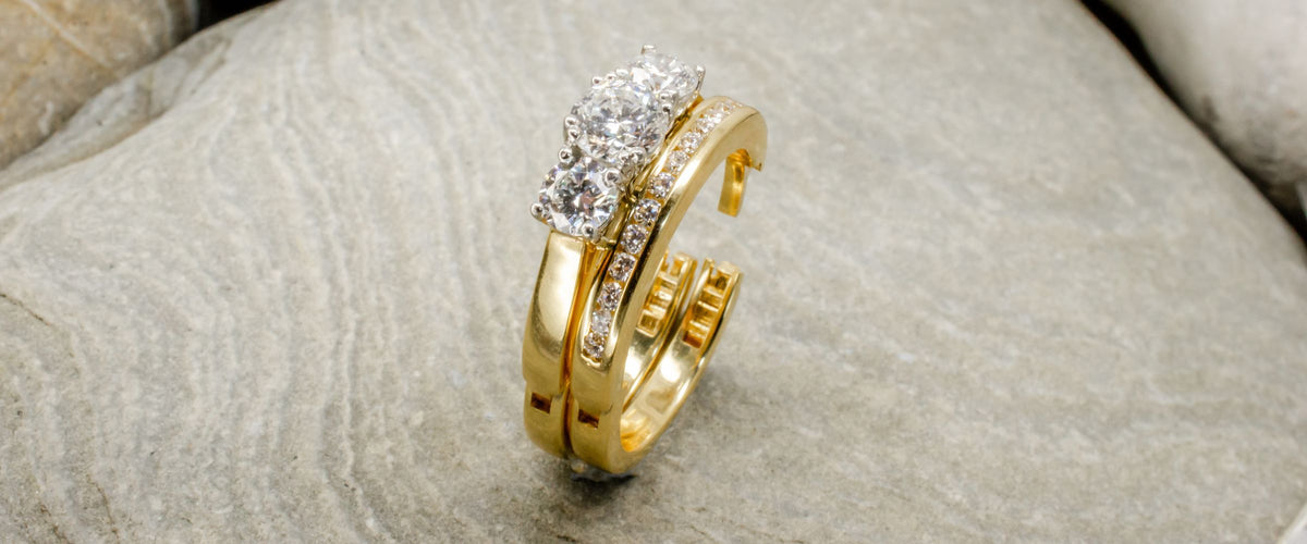 Hinged wedding and engagement ring on rock background