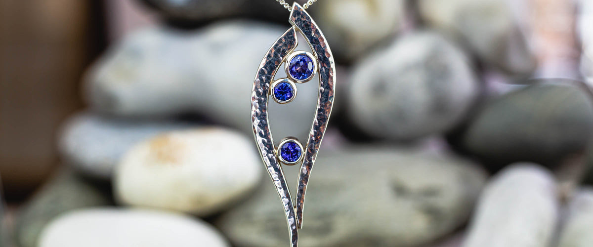 Tanzanite Pendant in Front of a Pebble Background