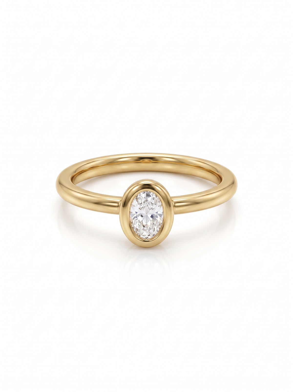 Oval cut diamond engagement ring in a yellow gold bezel setting on a white background.