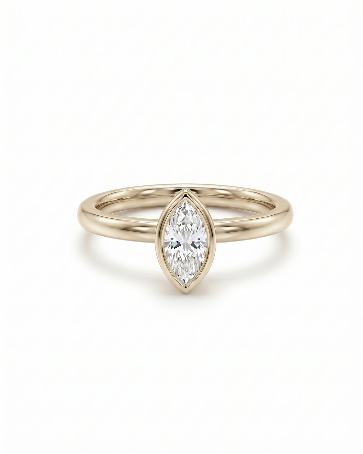 Marquise cut diamond engagement ring in a yellow gold bezel setting on a white background.