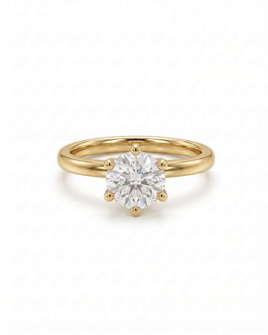 Round cut diamond solitaire engagement ring in 18k yellow gold with a six-claw setting.