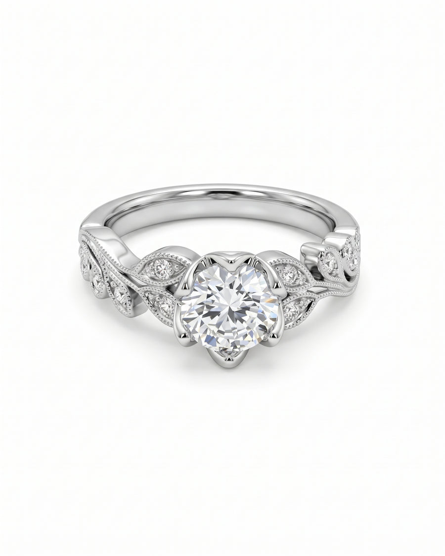 Vintage platinum engagement ring with a round diamond center stone and leaf-inspired diamond side accents.