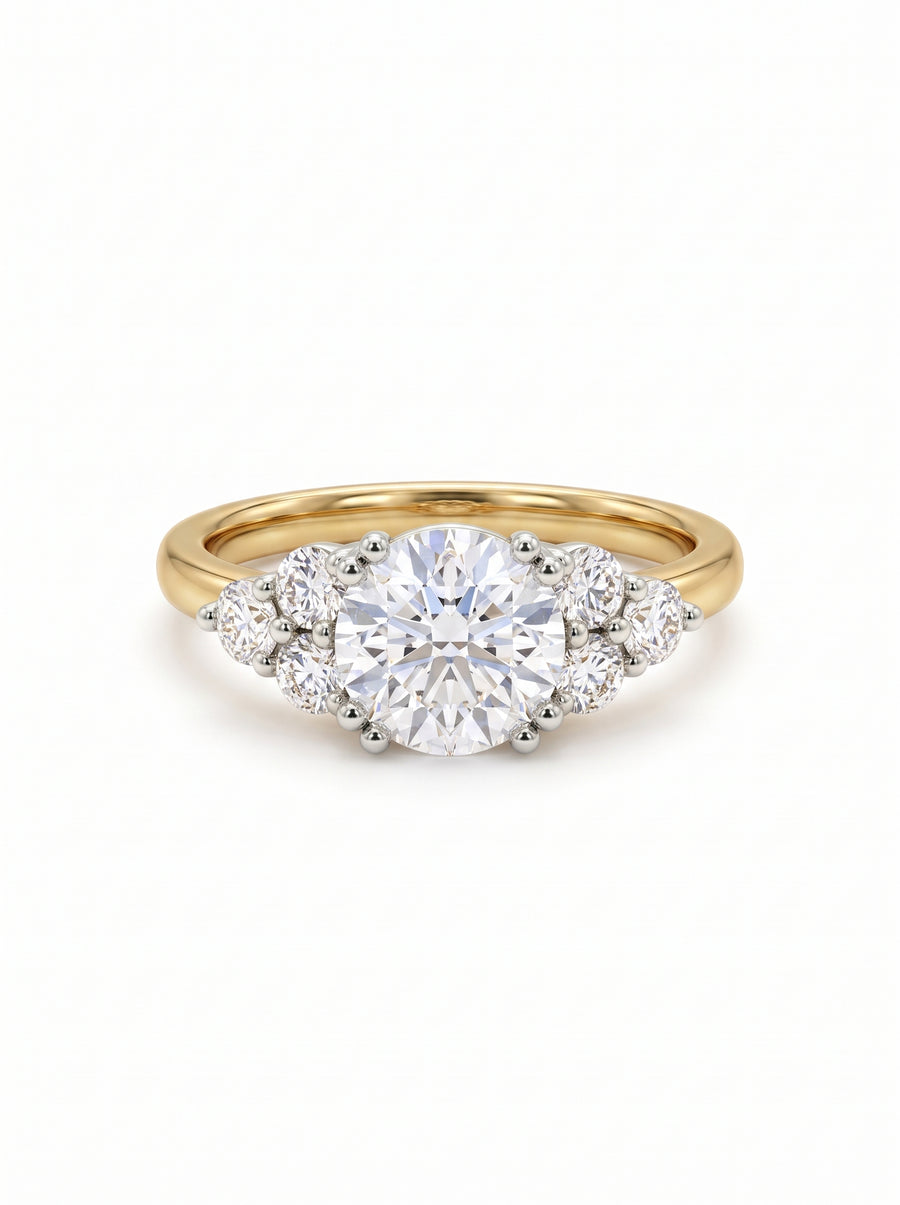 Round cut diamond engagement ring with a gold band and trefoil claw setting on a white background.
