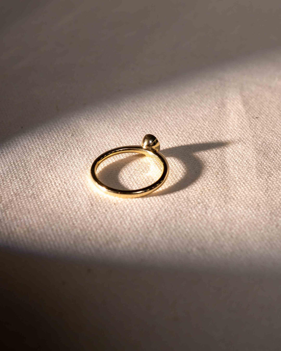 Gold engagement ring with an oval cut natural diamond in a bezel setting.