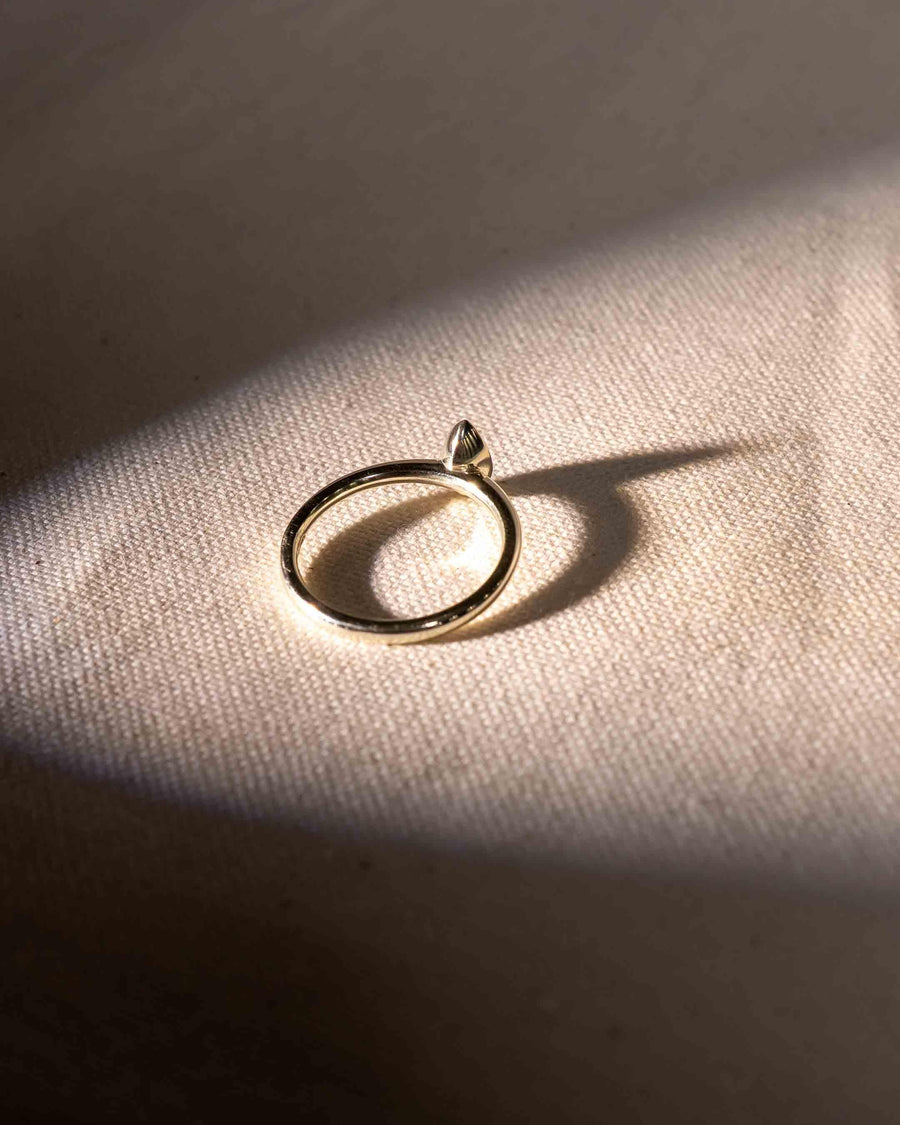Yellow gold ring with a marquise cut natural diamond in a bezel setting.