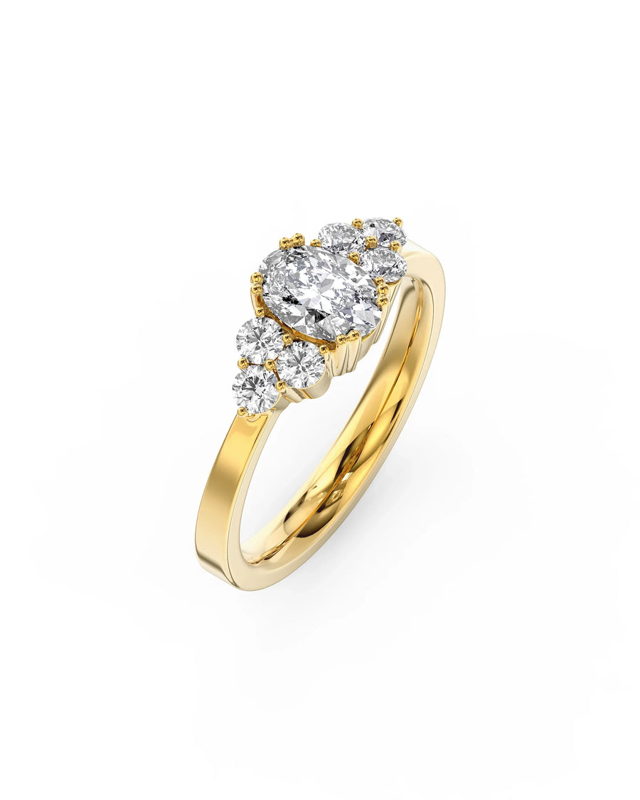 Handmade gold ring with oval and round cut diamonds in a unique claw setting on white background