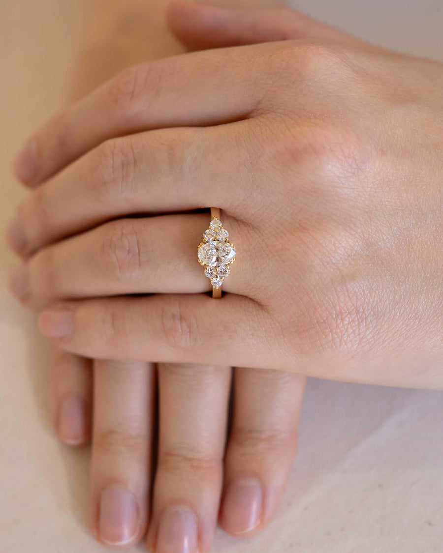Hand wearing a handmade gold diamond ring with organic, luxury jewellery design
