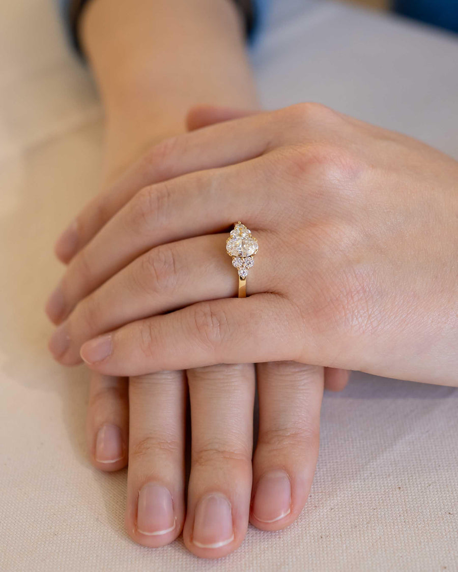 Hand wearing a gold cluster diamond ring, showcasing bespoke handmade luxury jewellery design
