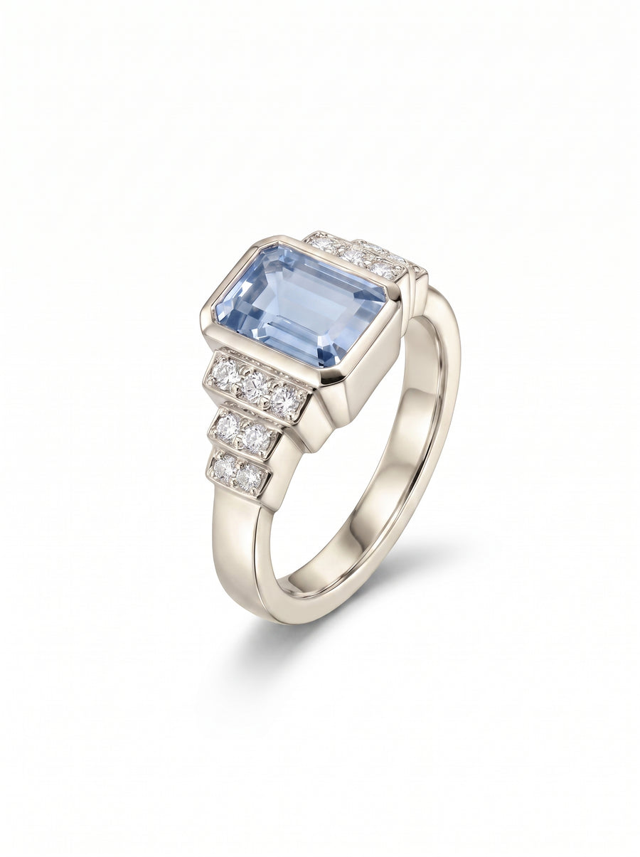 Art deco engagement ring with a rectangular aquamarine and diamond accents set in polished white gold.