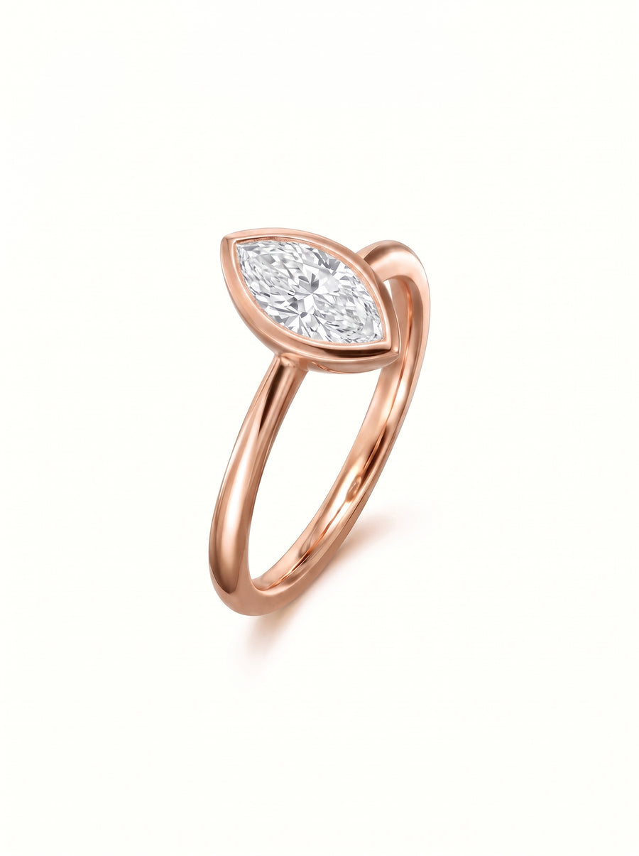 Rose gold engagement ring featuring a marquise cut diamond set in a smooth bezel setting.