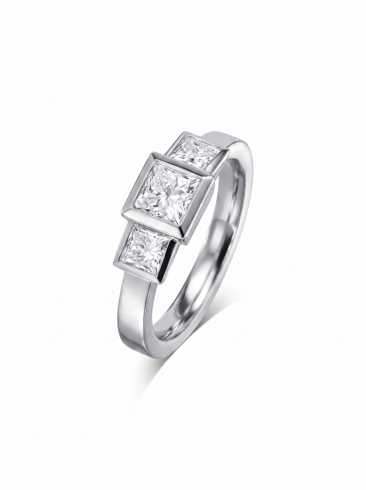Trilogy engagement ring featuring three princess cut diamonds in a silver-toned metal bezel setting.