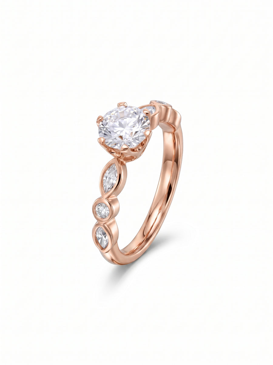 Rose gold engagement ring featuring a round cut center diamond with marquise and round side stones.