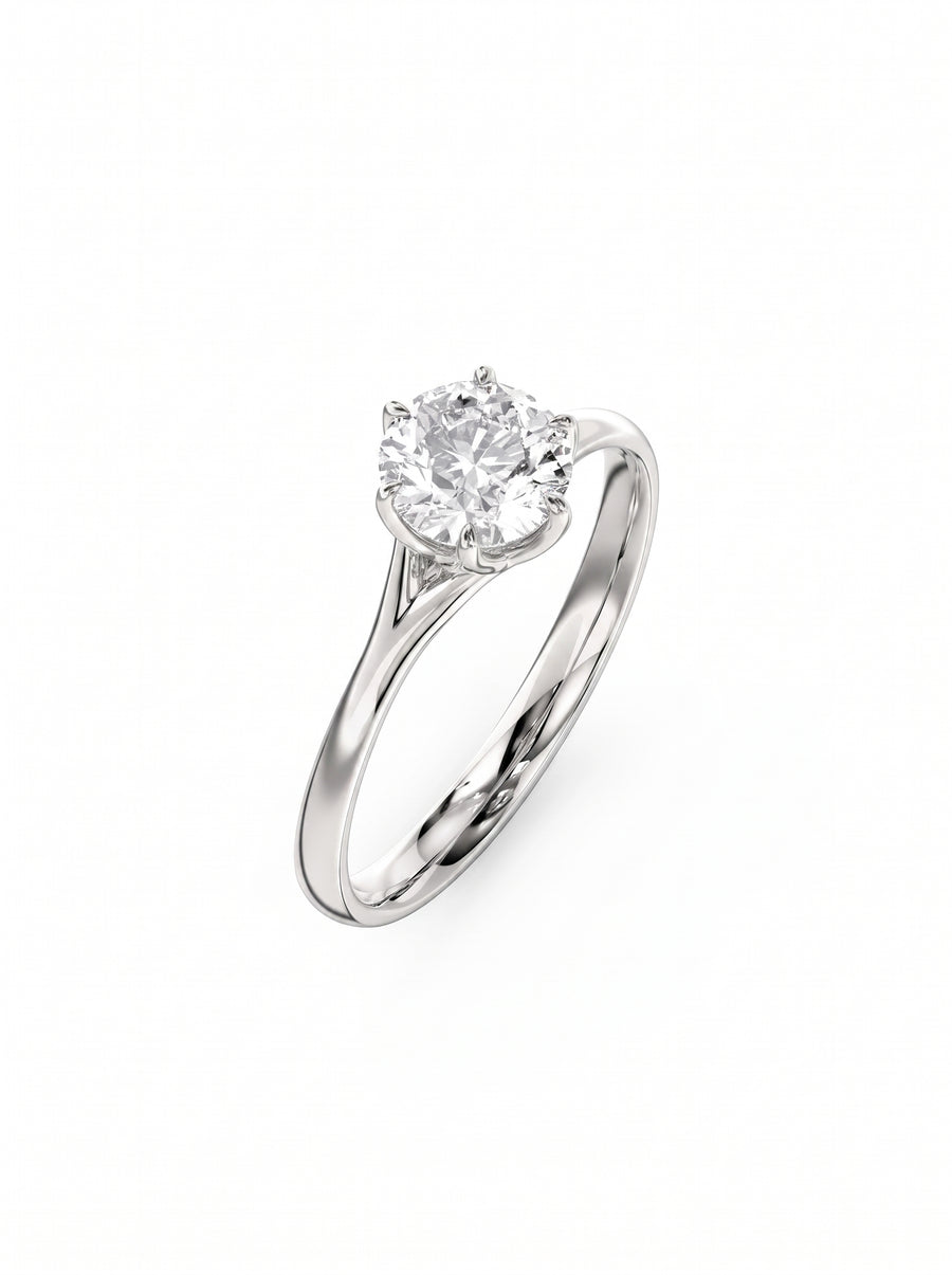 Round cut diamond engagement ring in a silver-toned metal band with a six-prong tulip claw setting.