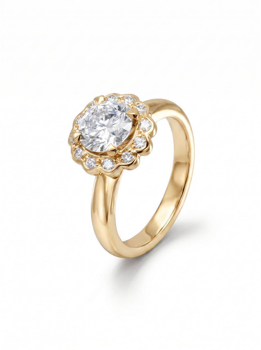 Gold engagement ring with a round diamond center stone in a scalloped cluster setting with small diamonds.