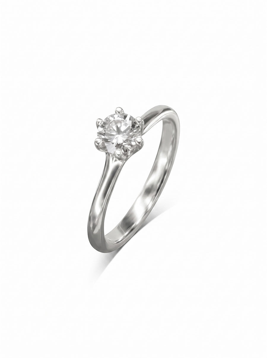 Round diamond solitaire engagement ring in a silver-toned metal with a six-claw v-setting.