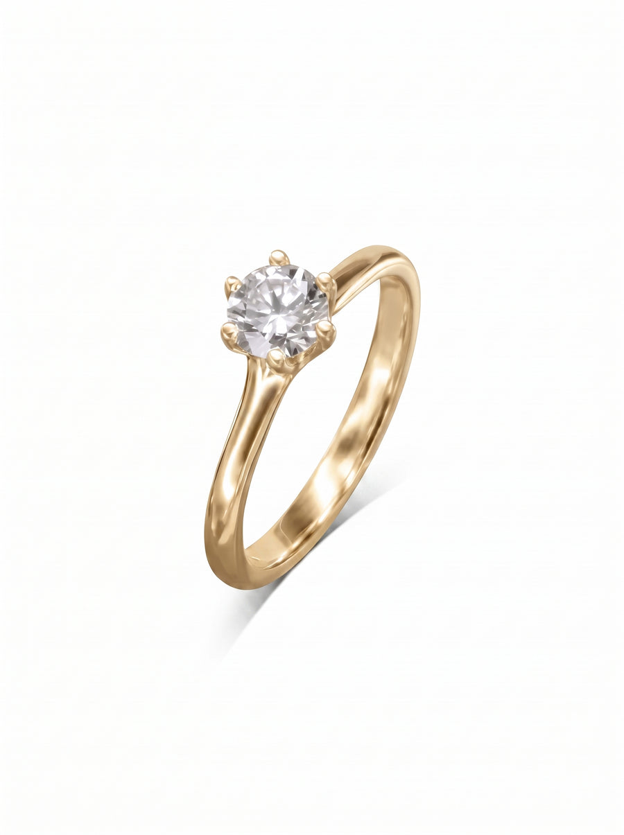 Gold solitaire engagement ring with a round brilliant diamond in a six-claw v-setting.