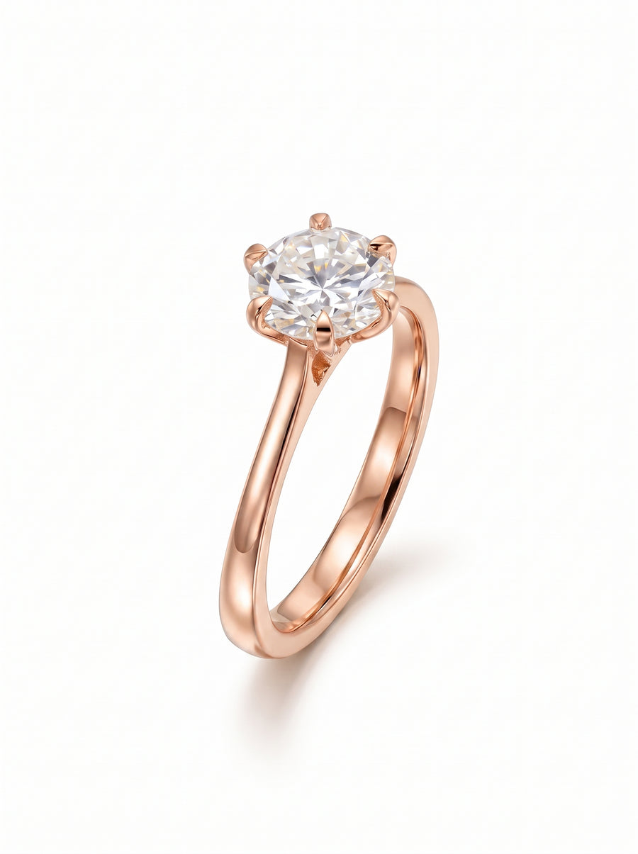 Rose gold solitaire engagement ring featuring a round cut diamond in a six-prong talon setting.