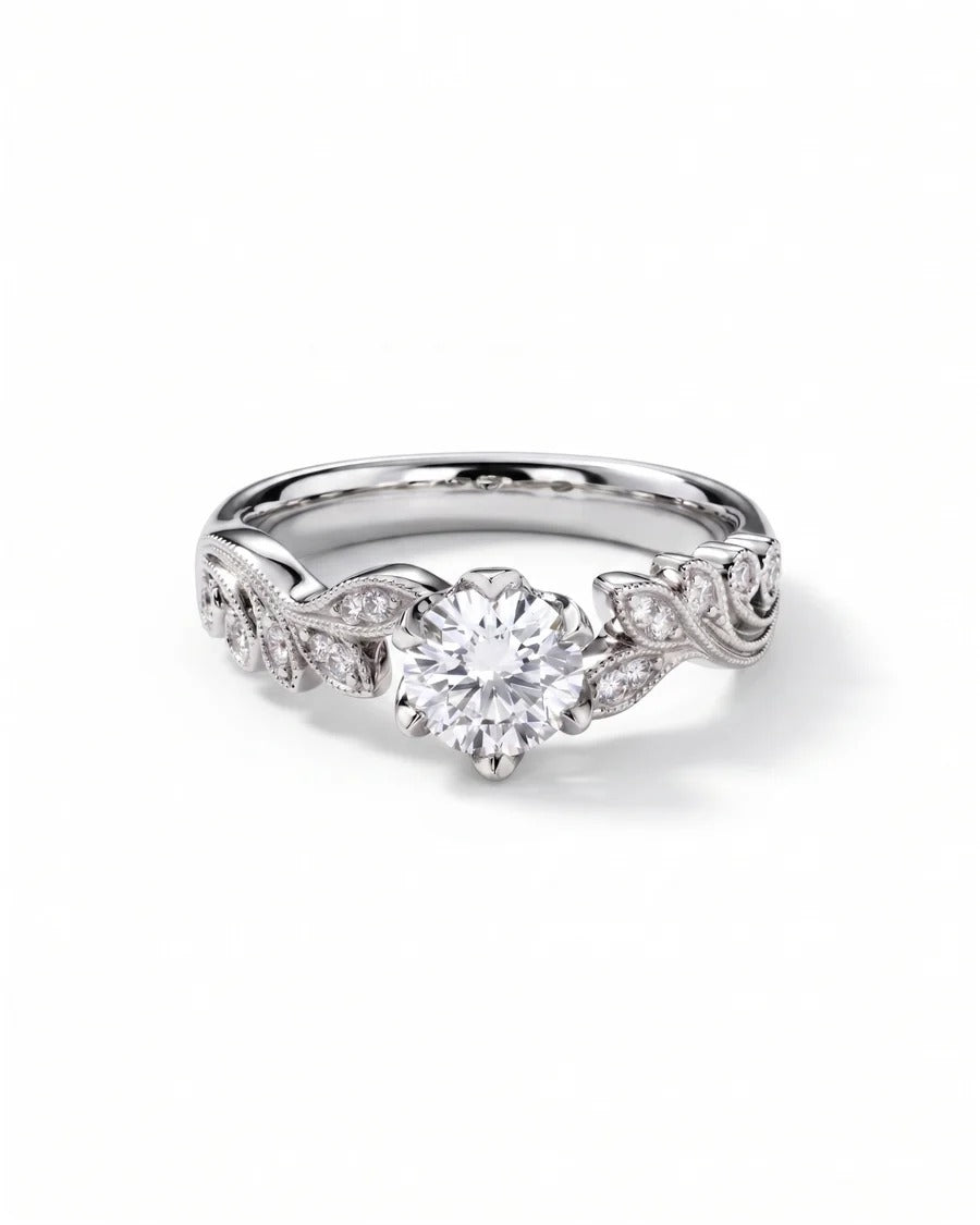Silver engagement ring with a round diamond center stone and leaf-shaped diamond accents on the band.