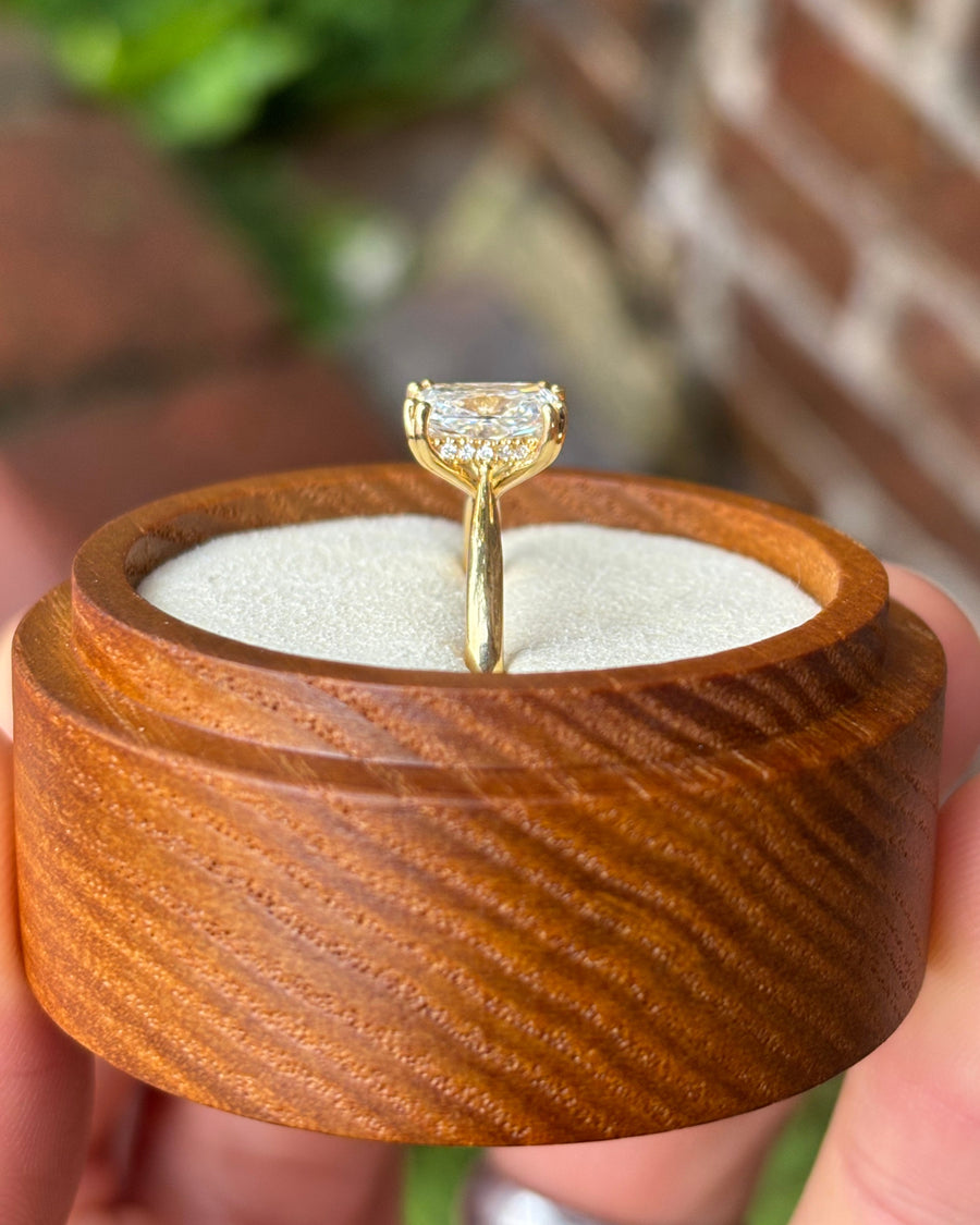 Cushion cut diamond engagement ring with a hidden halo set in a yellow gold band.