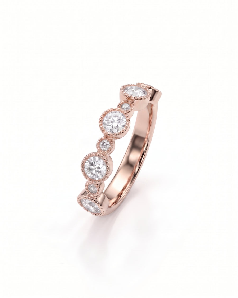 Rose gold eternity ring with alternating bezel-set round diamonds.