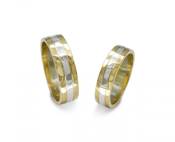 Wide flat wedding bands in yellow and white gold with a hammered texture finish.