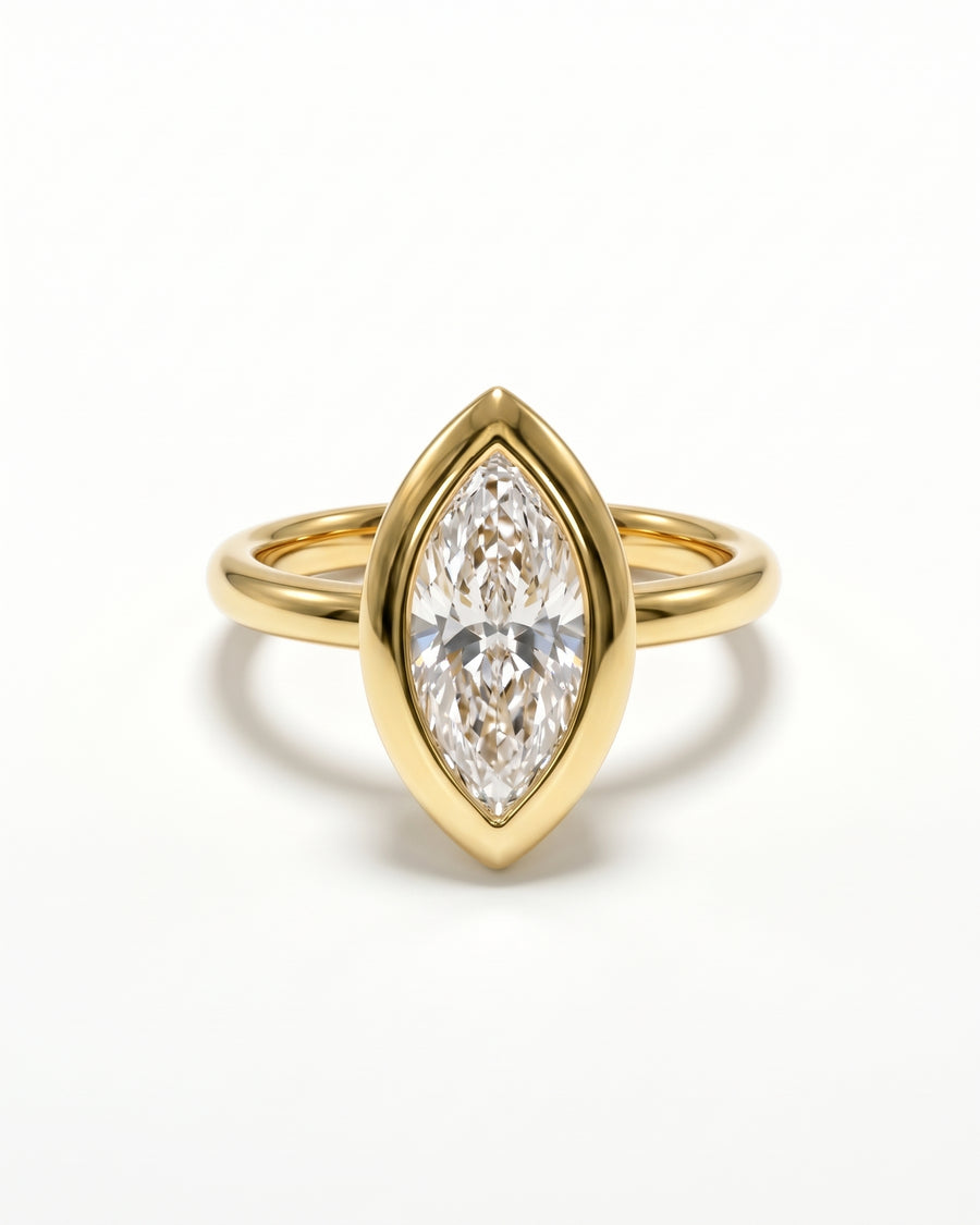 Marquise cut lab-grown diamond engagement ring in a yellow gold bezel setting on a plain band.