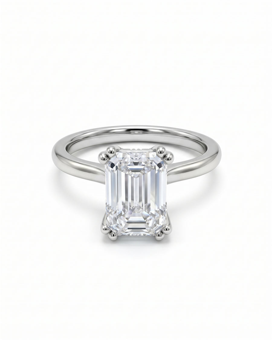Emerald cut lab-grown diamond engagement ring set in a polished platinum band with a hidden halo.