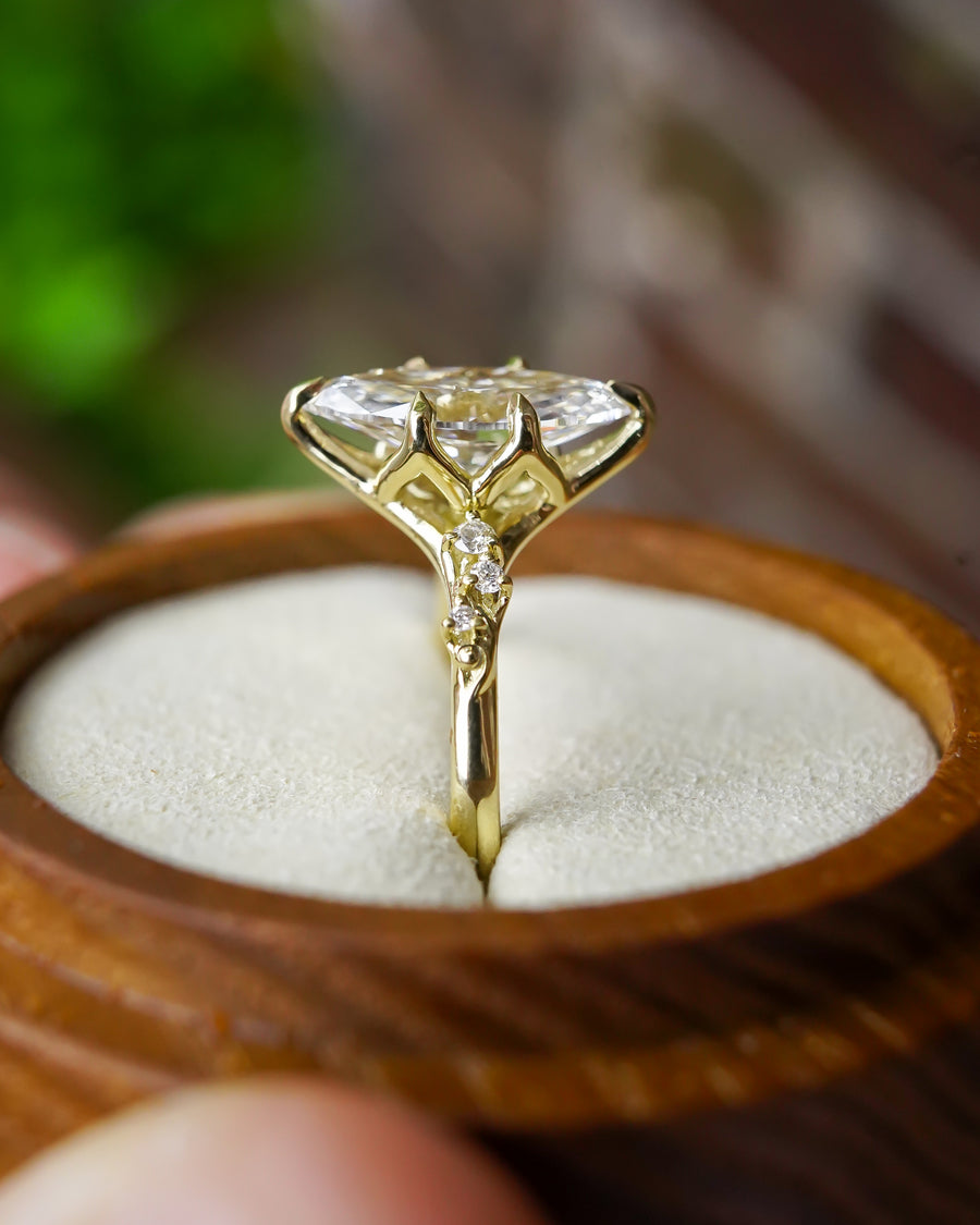 Marquise-cut lab-grown diamond engagement ring in yellow gold with a floral vine band design.