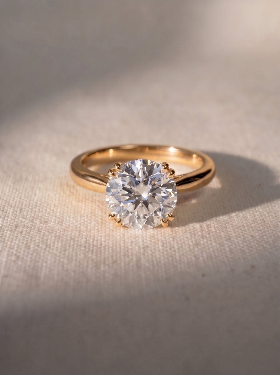 Round cut diamond engagement ring with a hidden halo set in a polished yellow gold band.