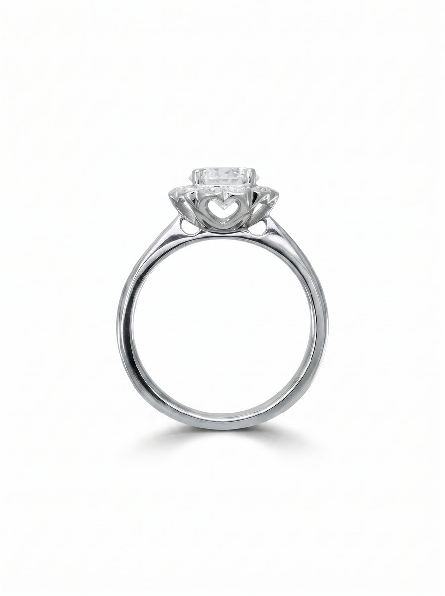 Silver engagement ring with a scalloped diamond cluster setting and heart-shaped cutouts on the side gallery.