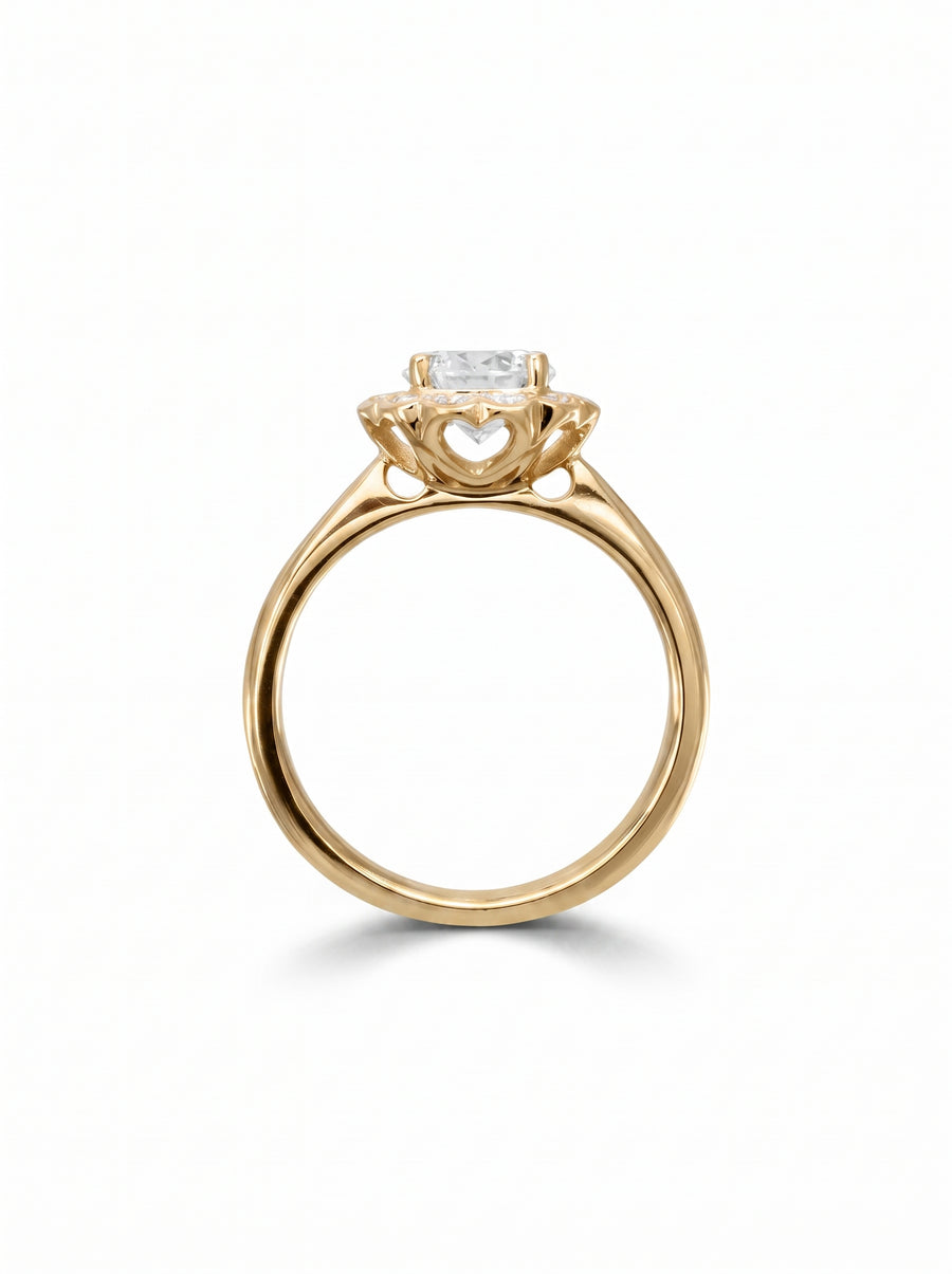 Gold engagement ring with a scalloped diamond cluster setting and heart-shaped side cutouts.