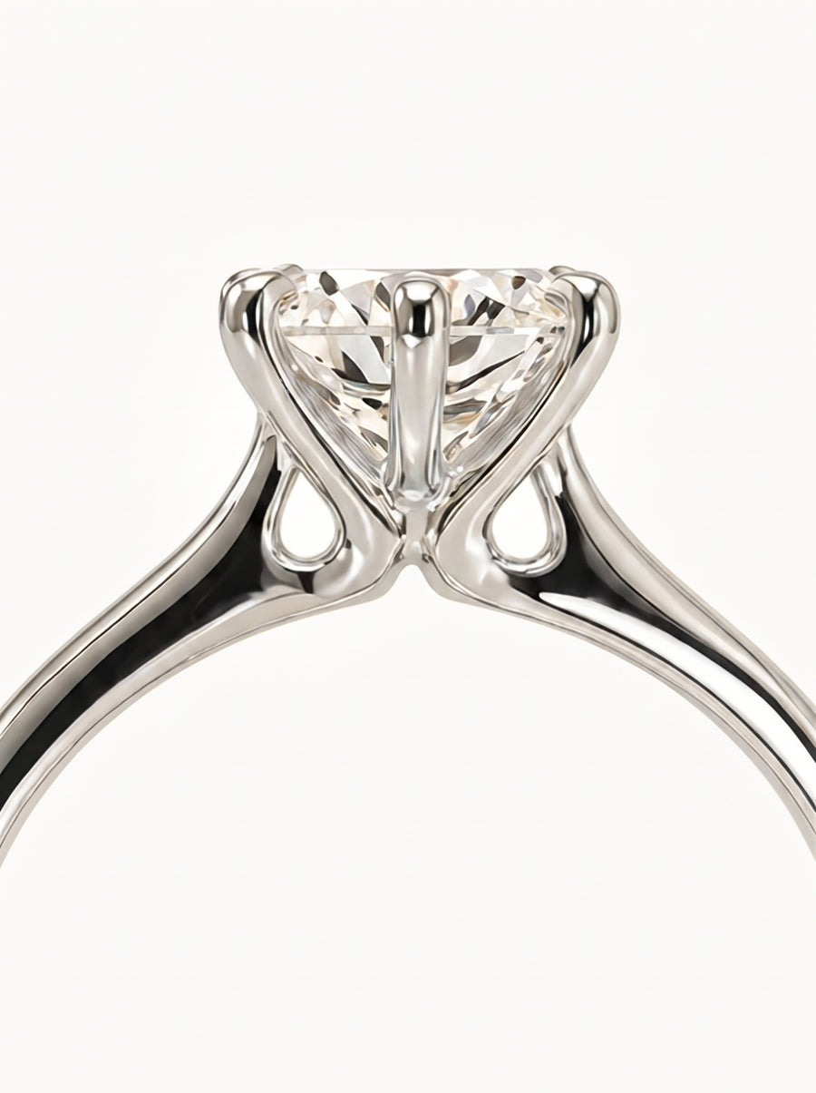 Round cut diamond solitaire engagement ring in polished white gold with a talon prong setting.