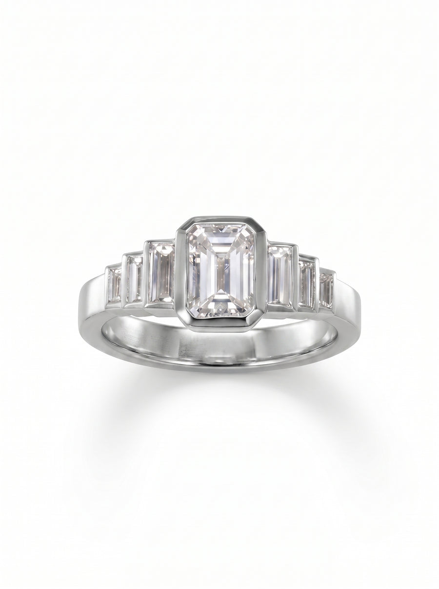 Platinum engagement ring featuring a central emerald cut diamond flanked by six graduated baguette cut diamonds.