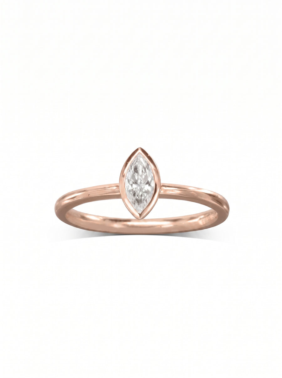 Rose gold engagement ring featuring a marquise cut diamond in a smooth bezel setting.