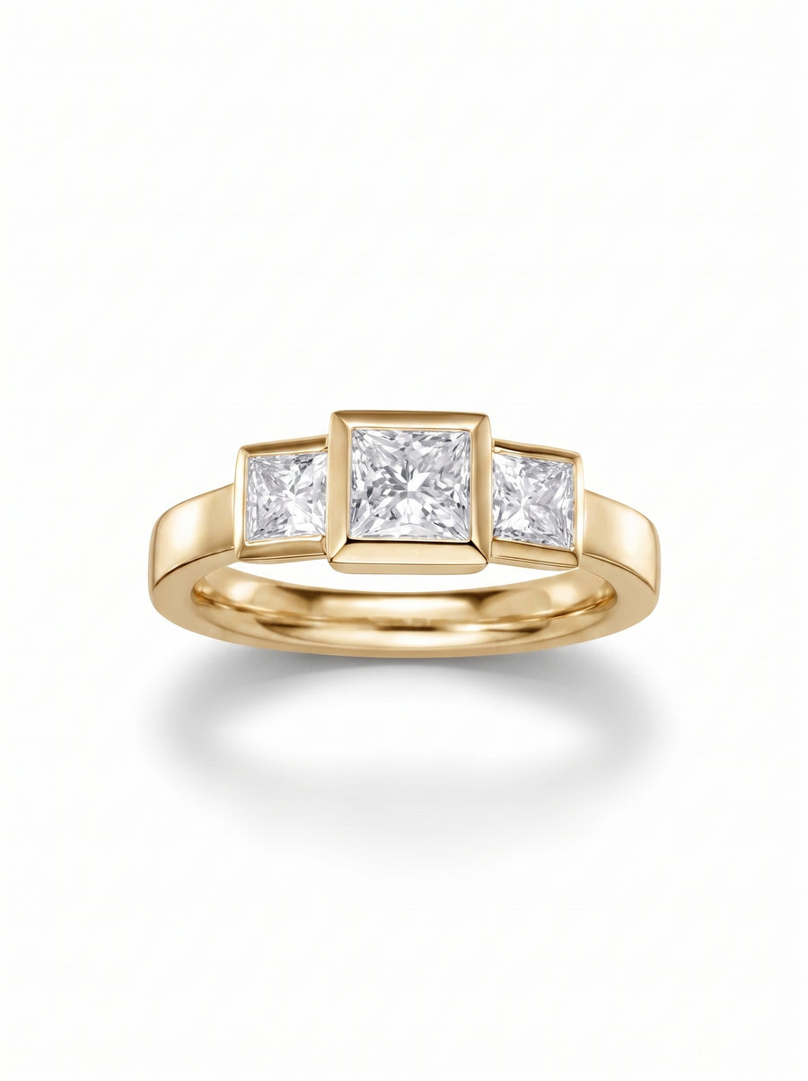 Trilogy engagement ring with three princess cut diamonds in a yellow gold bezel setting.