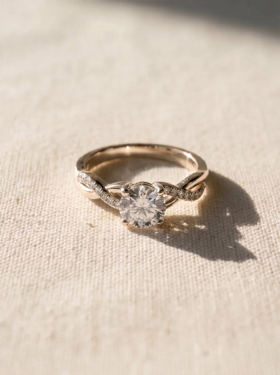 Round cut diamond engagement ring with a twisted rose gold band featuring small pavé accent stones.