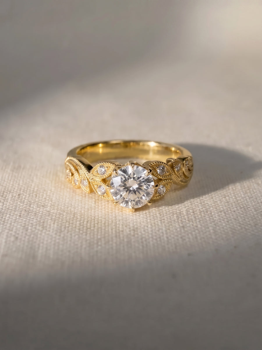 18ct yellow gold engagement ring with a round cut lab grown diamond and leaf-inspired vintage detailing.
