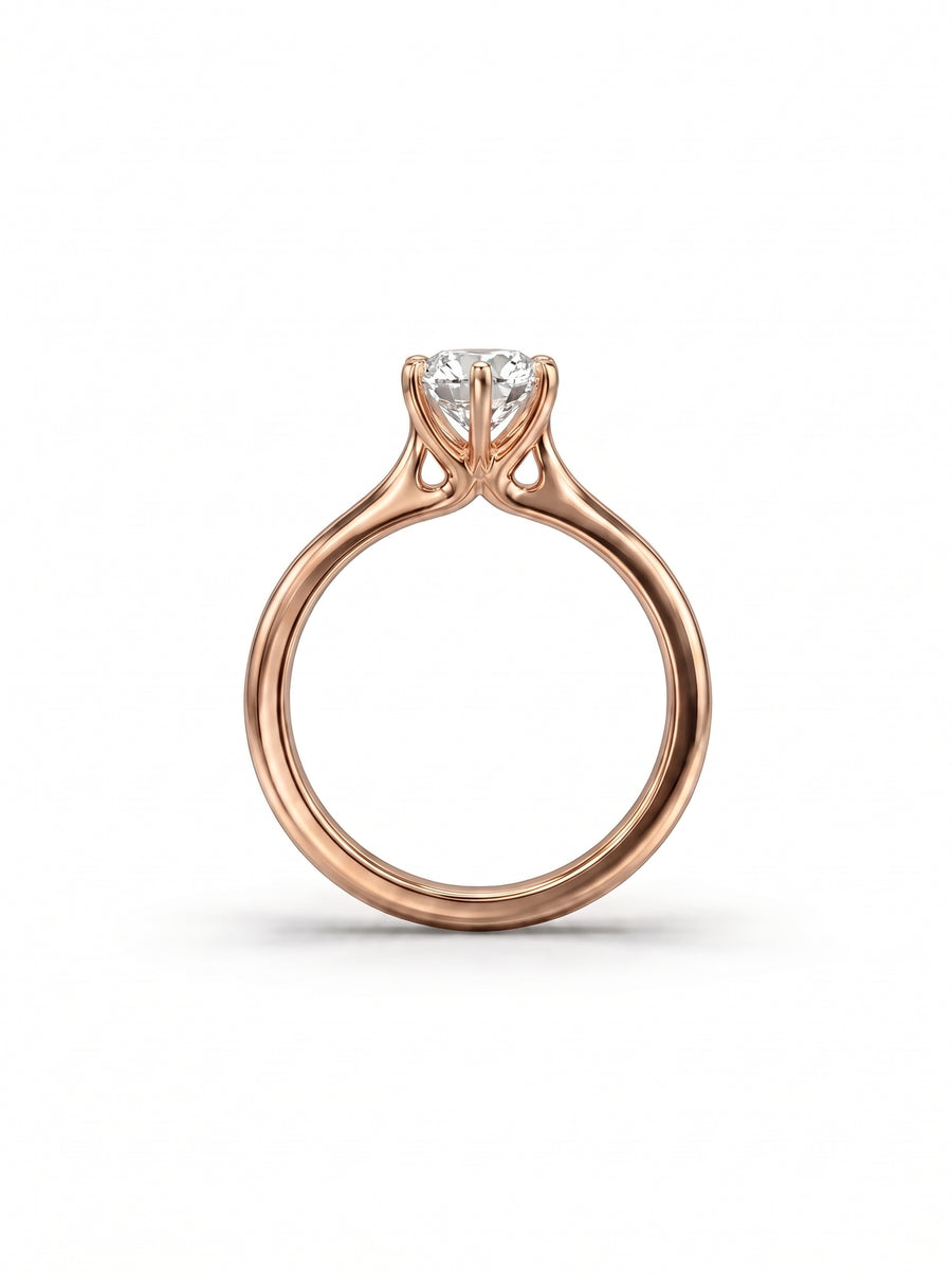 Rose gold engagement ring with a round brilliant diamond held in a six-claw setting.