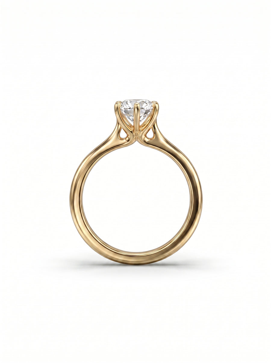 Gold engagement ring with a round brilliant diamond held in a six-claw setting on a polished band.