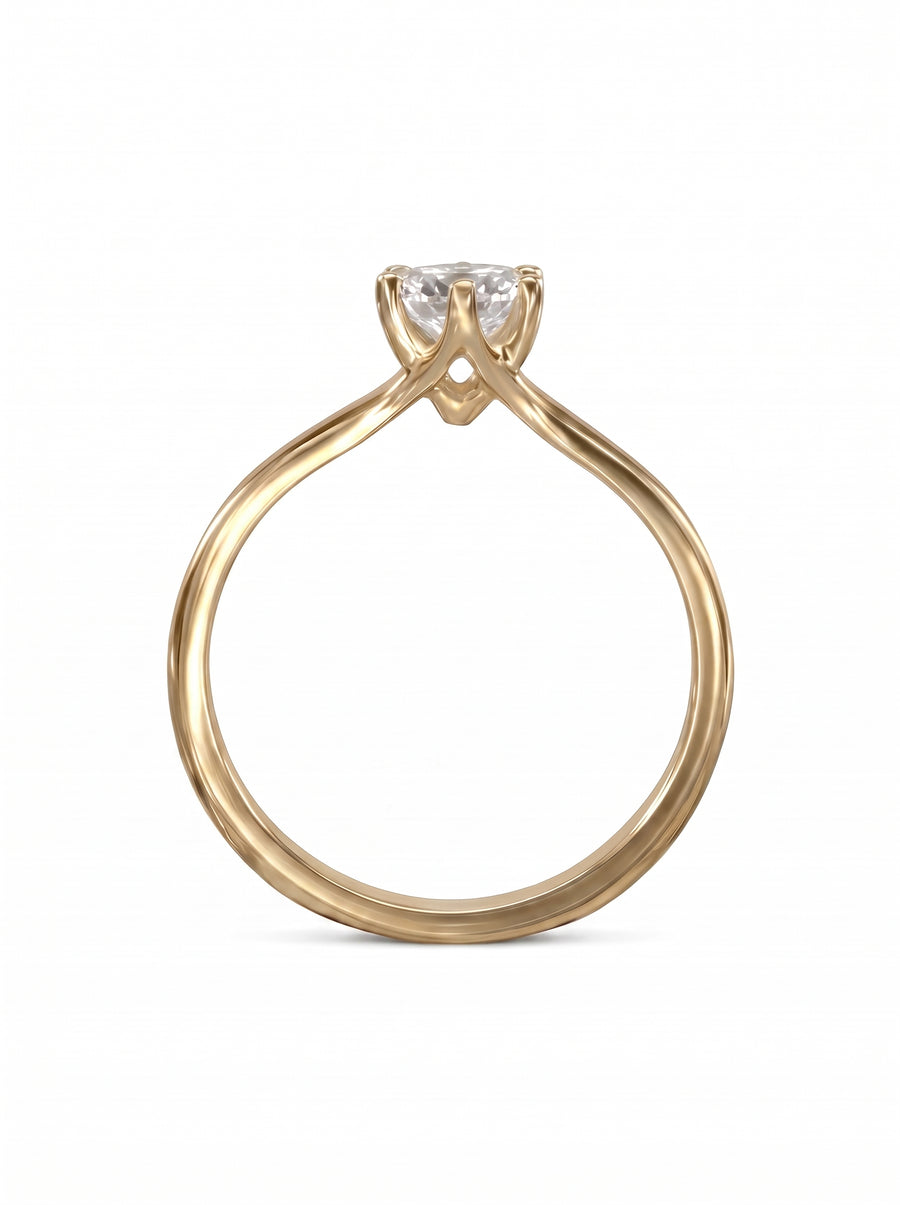 Gold solitaire engagement ring with a round diamond in a six-claw V-shaped setting.