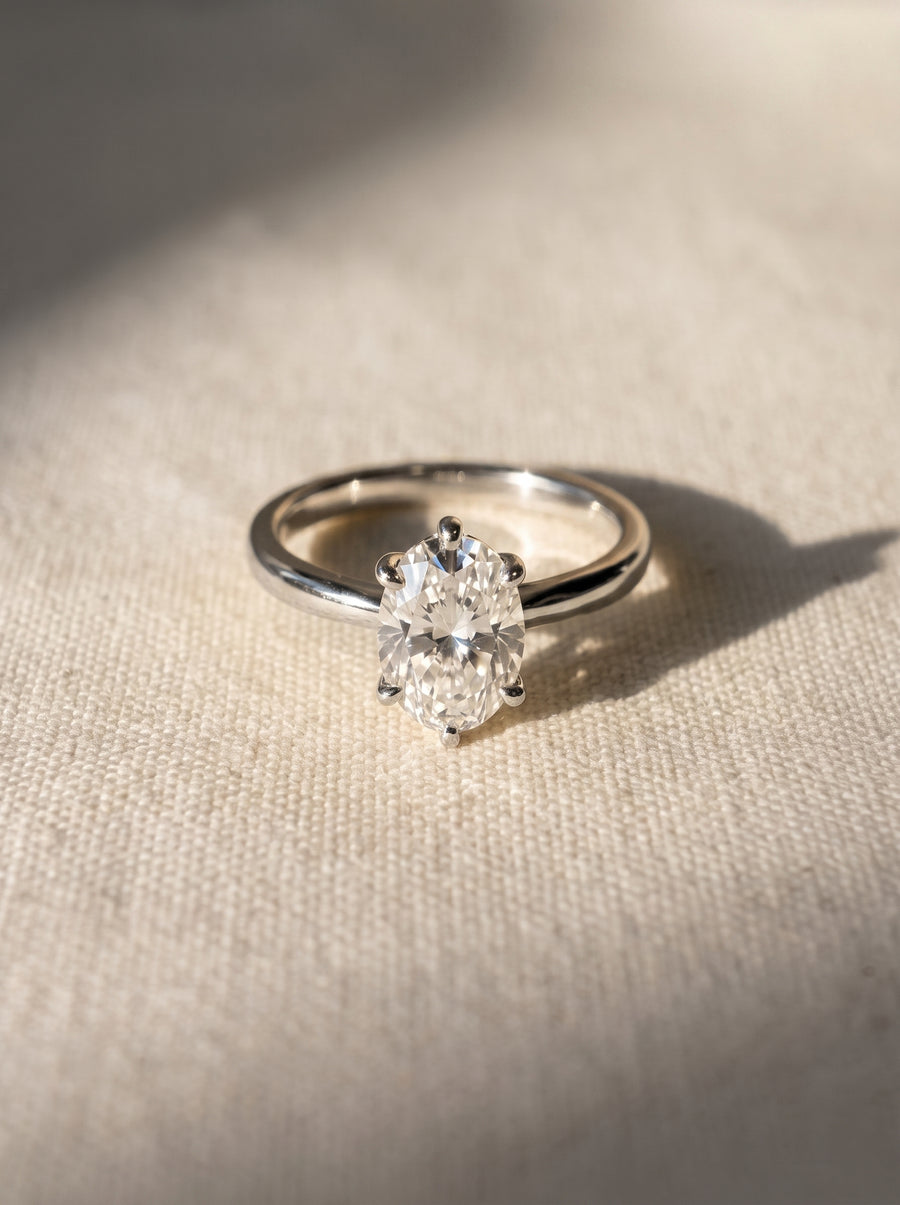 Oval diamond engagement ring with a six-prong setting on a polished silver band.