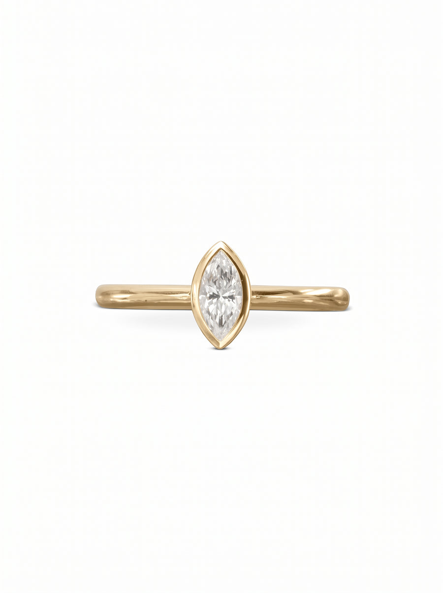 Marquise cut diamond engagement ring in a yellow gold bezel setting on a plain band.
