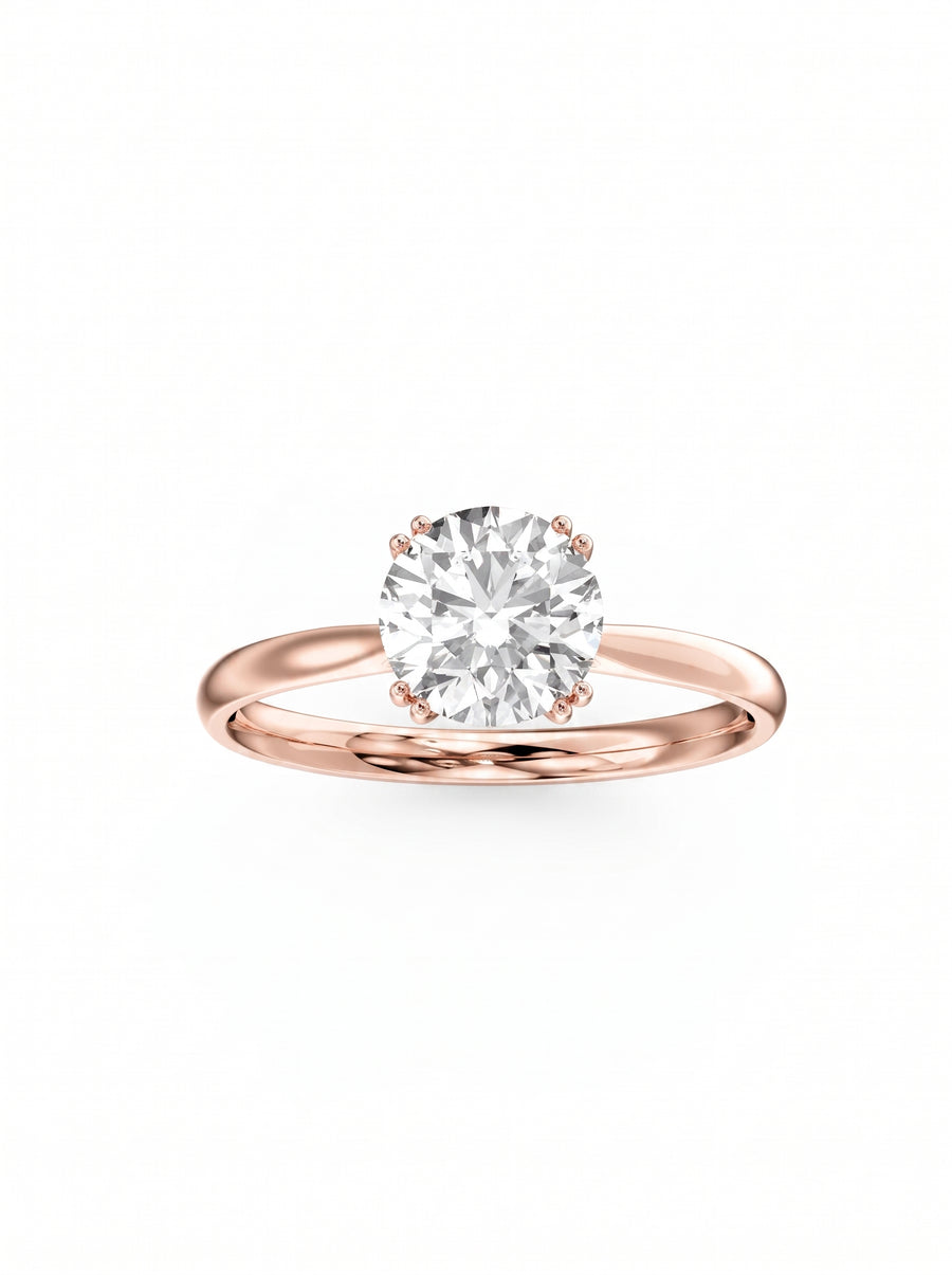 Round cut diamond engagement ring set in a polished rose gold band with a hidden halo setting.
