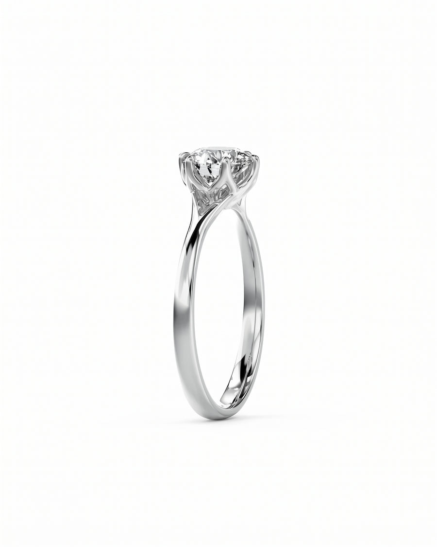 Round cut diamond engagement ring in polished platinum with a six-prong tulip claw setting.